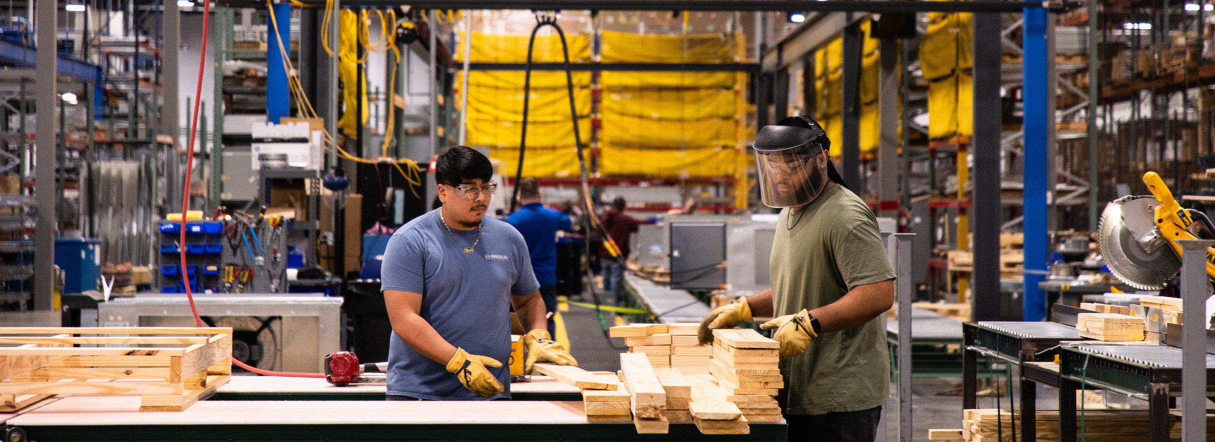Men trimming wood in plant